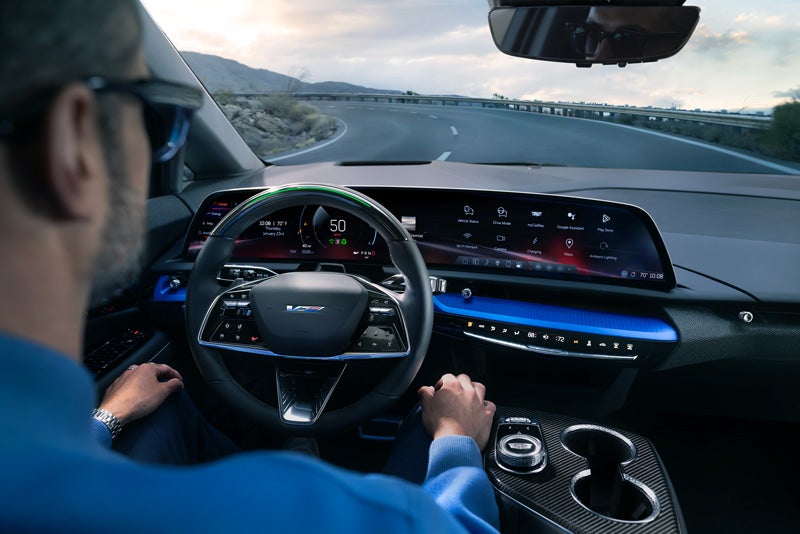 Front View of the 2026 OPTIQ-V Driving Through the Dusk Utilizing its Headlights | Sudbay Cadillac in Gloucester MA